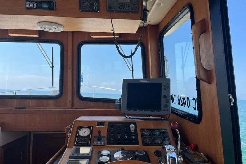 Nomad Yacht Photos Pics Pilothouse interior of a 2000 Nordic Tug 37, featuring navigation equipment and ocean view.