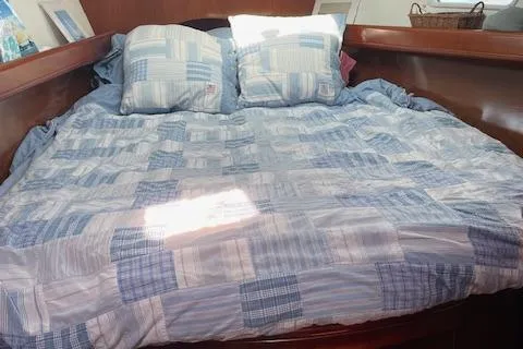 Peregrine Yacht Photos Pics Cozy cabin bed with blue checkered bedding on a 2005 Beneteau 423 yacht.