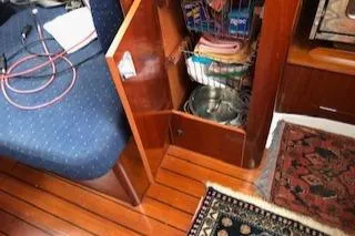Peregrine Yacht Photos Pics Interior of a 2005 Beneteau 423 sailboat with open wooden cabinet and blue seating.