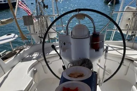 Peregrine Yacht Photos Pics Cockpit view of a 2005 Beneteau 423 sailboat with steering wheel and ocean backdrop.