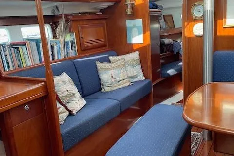 Peregrine Yacht Photos Pics Interior of 2005 Beneteau 423 yacht with blue seating and wooden furnishings.