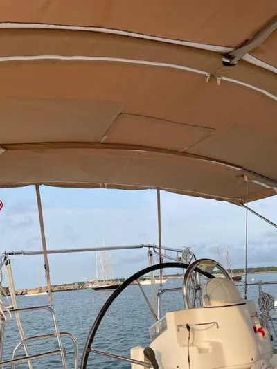 Peregrine Yacht Photos Pics 2005 Beneteau 423 sailboat cockpit with steering wheel and canopy, docked in a marina.