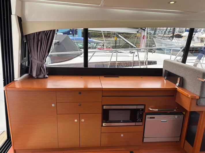  Yacht Photos Pics Interior of 2014 Jeanneau NC 14 yacht with modern kitchen appliances and wood cabinetry.