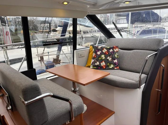  Yacht Photos Pics Interior of 2014 Jeanneau NC 14 yacht with cozy seating and colorful pillow.