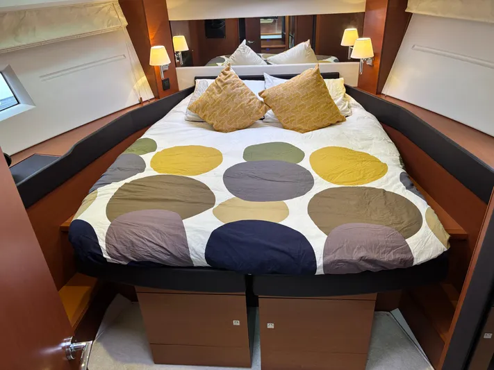  Yacht Photos Pics Luxurious bedroom interior of 2014 Jeanneau NC 14 yacht with modern bedding and ambient lighting.