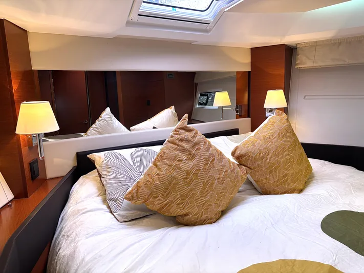  Yacht Photos Pics Luxurious bedroom interior of 2014 Jeanneau NC 14 yacht with plush pillows and ambient lighting.