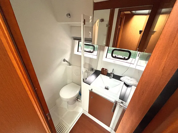  Yacht Photos Pics 2014 Jeanneau NC 14 bathroom with modern fixtures and wooden cabinetry.