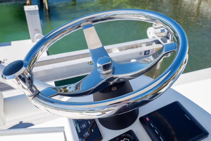  Yacht Photos Pics Steering wheel of a 2015 Intrepid 400 Center Console boat, docked by water.