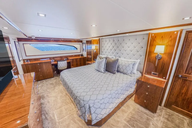 Marlin Magic Yacht Photos Pics Luxurious bedroom interior of 2021 Viking 92 Skybridge yacht with elegant wood finishes.