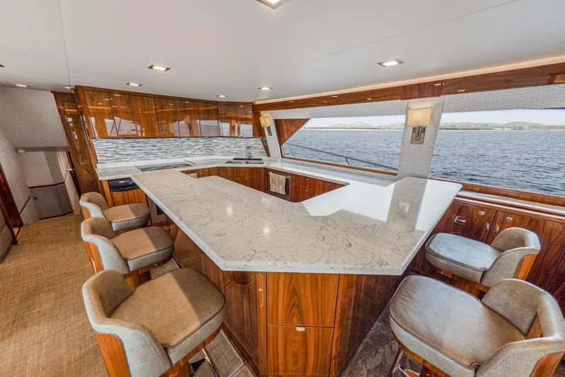 Marlin Magic Yacht Photos Pics Luxurious interior of 2021 Viking 92 Skybridge yacht with elegant bar and seating.