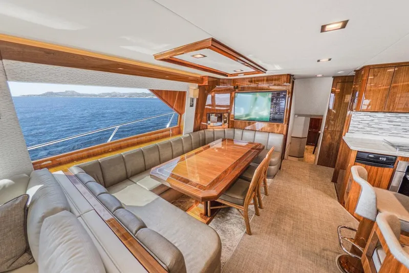 Marlin Magic Yacht Photos Pics Luxurious interior of 2021 Viking 92 Skybridge yacht with ocean view and elegant dining area.