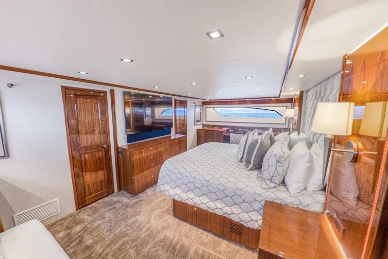 Marlin Magic Yacht Photos Pics Luxurious bedroom interior of 2021 Viking 92 Skybridge yacht with elegant wood finishes.
