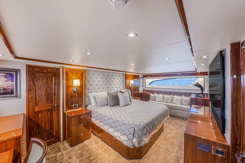 Marlin Magic Yacht Photos Pics Luxurious bedroom interior of 2021 Viking 92 Skybridge yacht with elegant wood finishes.