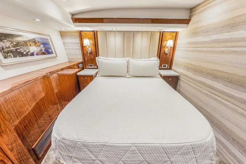 Marlin Magic Yacht Photos Pics Luxurious bedroom interior of 2021 Viking 92 Skybridge yacht with elegant wood finishes.