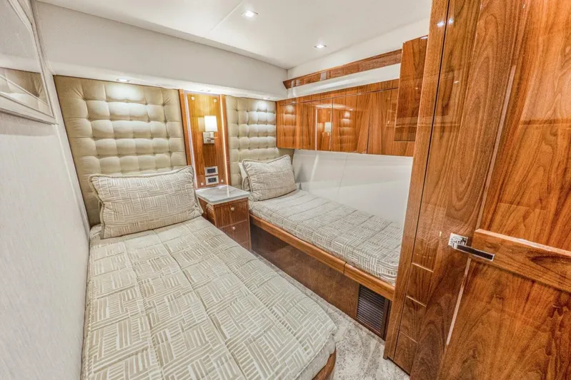 Marlin Magic Yacht Photos Pics Luxurious 2021 Viking 92 Skybridge cabin with twin beds and elegant wood finishes.