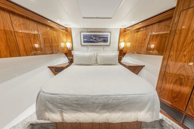 Marlin Magic Yacht Photos Pics Luxurious bedroom interior of 2021 Viking 92 Skybridge yacht with elegant wood paneling.