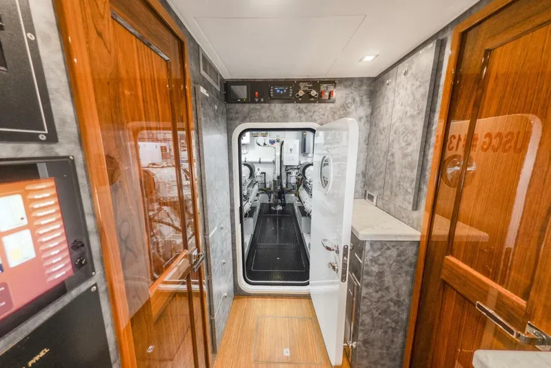 Marlin Magic Yacht Photos Pics Engine room entrance of 2021 Viking 92 Skybridge yacht, featuring wood and metal finishes.