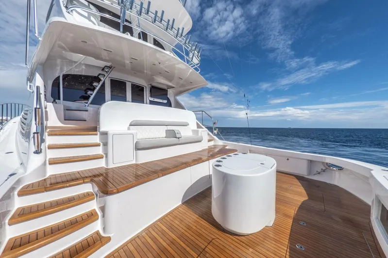 Marlin Magic Yacht Photos Pics Luxurious 2021 Viking 92 Skybridge yacht deck with wooden flooring and ocean view.