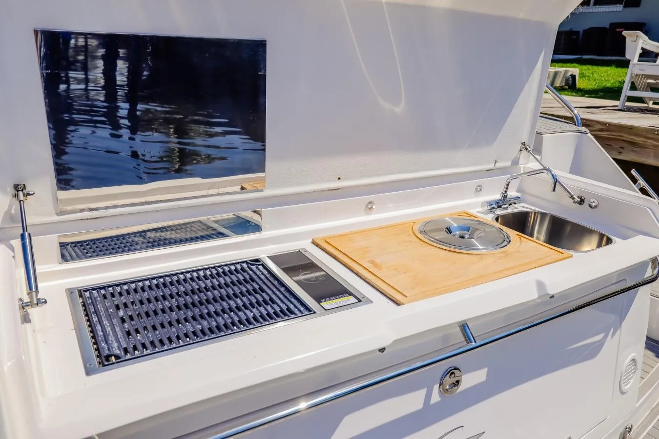 Outdoor kitchen on 2021 Evolve 400HT yacht with grill, sink, and cutting board.