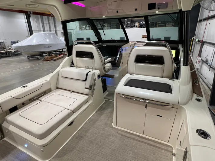  Yacht Photos Pics 2023 Chris-Craft Calypso 35 interior with luxurious seating and modern design in a showroom.