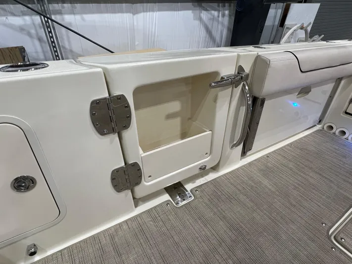  Yacht Photos Pics 2023 Chris-Craft Calypso 35 boat interior with open storage compartment and stainless steel handle.