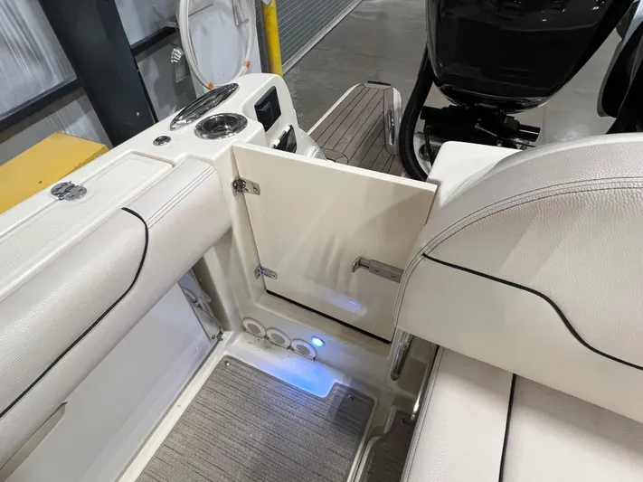  Yacht Photos Pics 2023 Chris-Craft Calypso 35 interior with open storage compartment and seating.