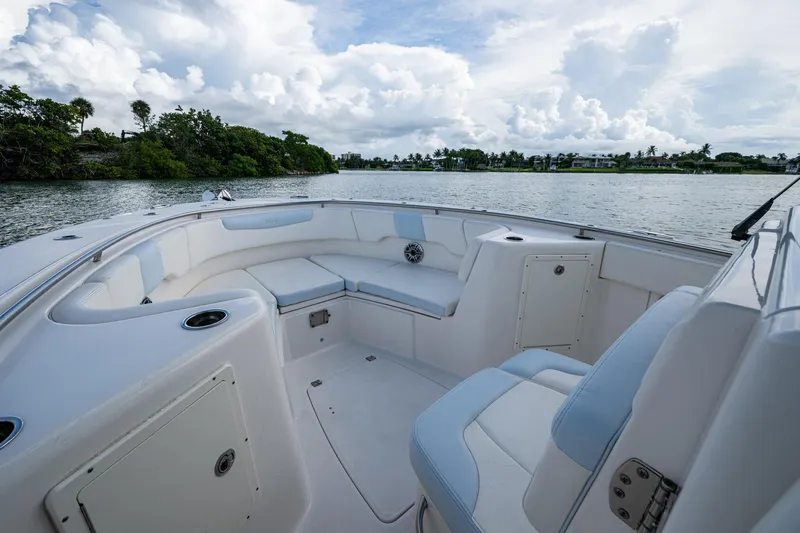 Mimi Too Yacht Photos Pics 2023 Robalo R302 Center Console boat interior with cushioned seating, on a scenic waterway.
