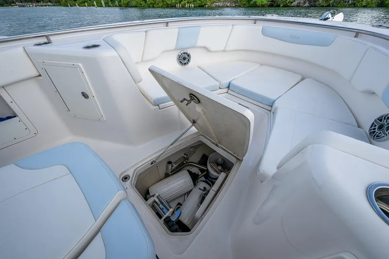 Mimi Too Yacht Photos Pics 2023 Robalo R302 Center Console boat interior with open storage compartment and cushioned seating.