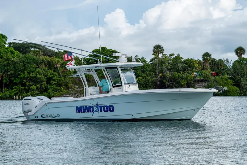 Mimi Too Yacht Photos Pics 2023 Robalo R302 Center Console boat on water, lush greenery background.