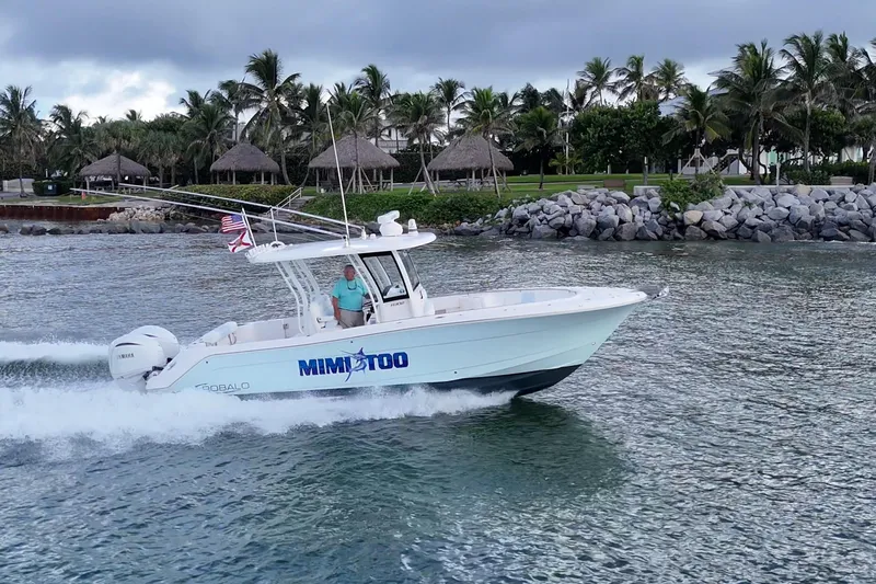 Mimi Too Yacht Photos Pics 2023 Robalo R302 Center Console boat cruising near a tropical shoreline.