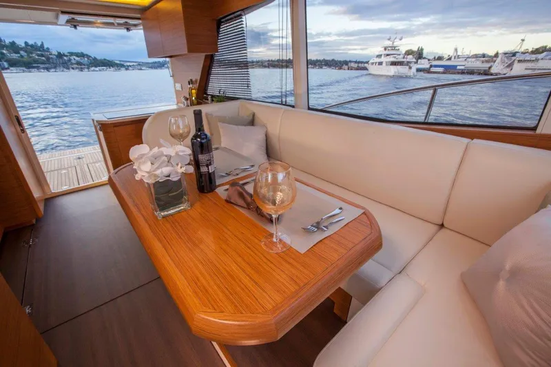 Pastiche Yacht Photos Pics Luxurious interior of 2019 Greenline Hybrid yacht with elegant dining setup and scenic water view.