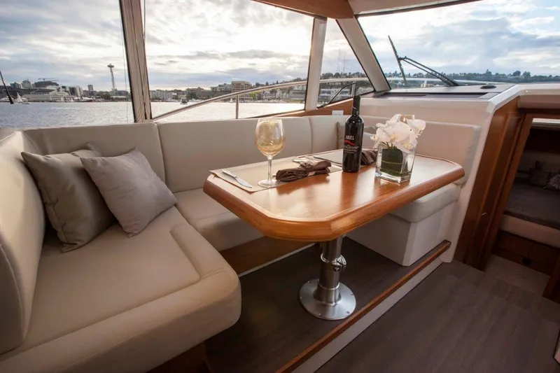 Pastiche Yacht Photos Pics Luxurious interior of 2019 Greenline Hybrid yacht with wine and flowers on table.