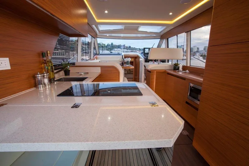 Pastiche Yacht Photos Pics Luxurious interior of a 2019 Greenline Hybrid yacht with modern kitchen and panoramic windows.