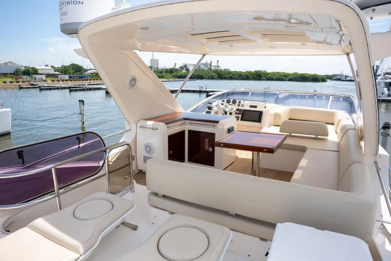 The Real D Yacht Photos Pics Luxurious 2013 Azimut 60 Flybridge yacht interior with seating and table, docked by the water.