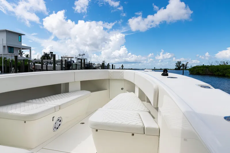  Yacht Photos Pics 2017 SeaVee 370z boat interior with white seating, docked by a waterfront home.