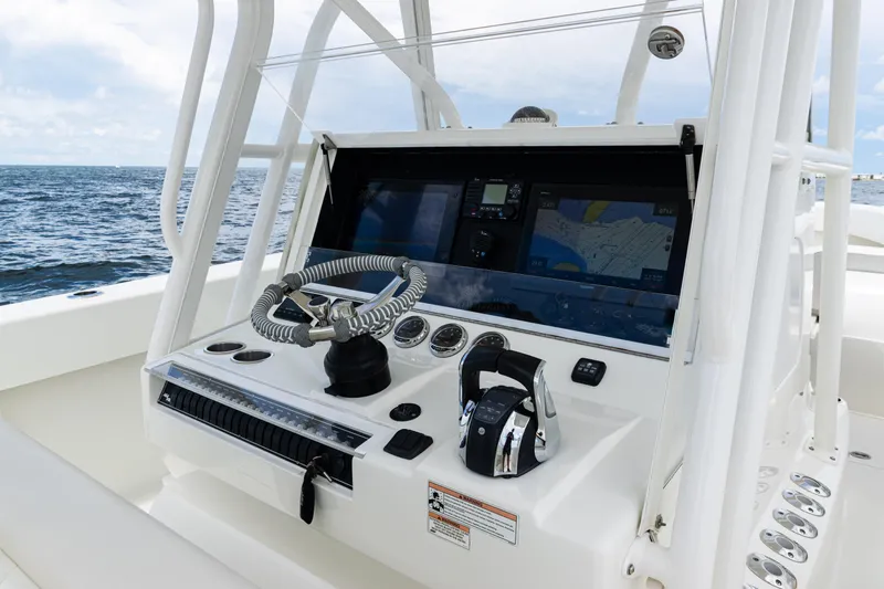  Yacht Photos Pics 2017 SeaVee 370z boat console with steering wheel and navigation screens on open water.