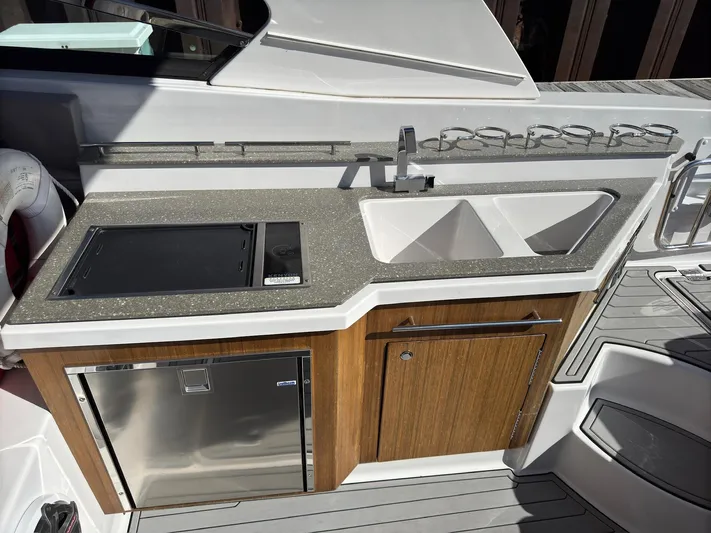 The Good Life Yacht Photos Pics Outdoor kitchen on 2019 Four Winns H350 boat with sink, stove, and fridge.