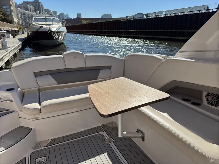 The Good Life Yacht Photos Pics 2019 Four Winns H350 boat interior with seating and table, docked in a sunny marina.
