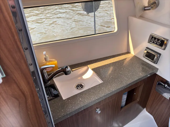 The Good Life Yacht Photos Pics 2019 Four Winns H350 boat interior with sink and countertop, featuring a window view.