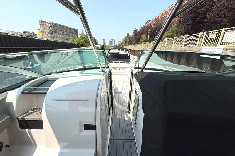 The Good Life Yacht Photos Pics 2019 Four Winns H350 boat docked in a canal, surrounded by urban buildings.