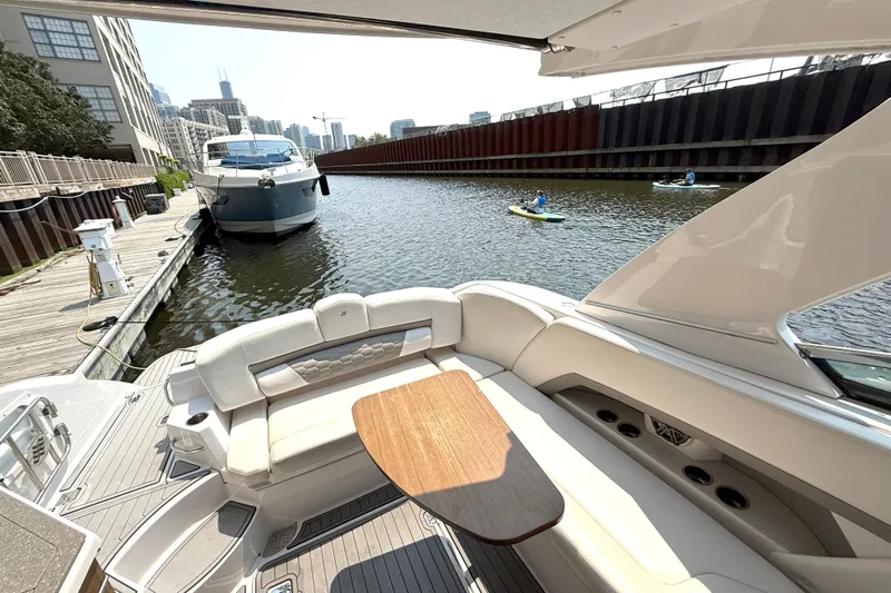 The Good Life Yacht Photos Pics 2019 Four Winns H350 yacht interior with waterfront view, docked near kayakers and cityscape.
