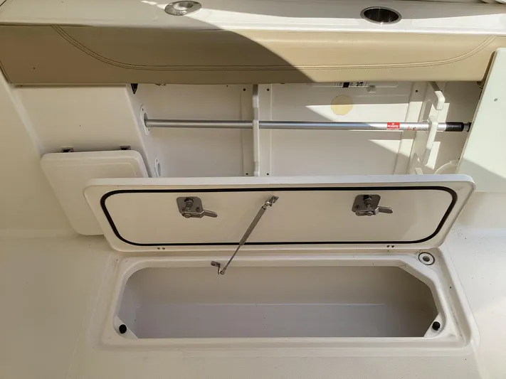  Yacht Photos Pics 2017 Pursuit DC 325 Dual Console storage compartment with open hatch and seating area.