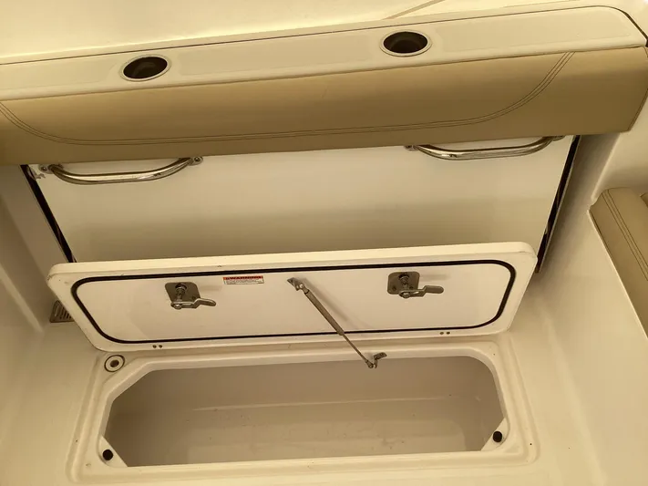  Yacht Photos Pics 2017 Pursuit DC 325 Dual Console storage compartment with open hatch and cushioned seating.