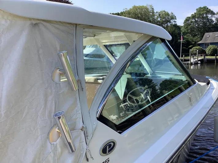  Yacht Photos Pics 2017 Pursuit DC 325 Dual Console boat docked, featuring sleek design and covered seating area.