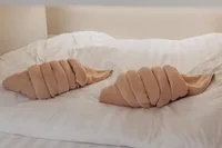Two towel swans on a neatly made bed in a cozy setting.