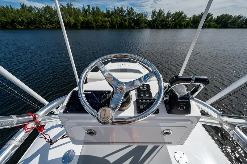 No Woke Zone Yacht Photos Pics 2019 Freeman 37 boat helm with steering wheel and controls on a calm lake.