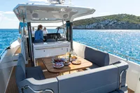 Luxurious Nimbus T11 yacht cruising with dining setup, 2022 model, on clear blue waters.