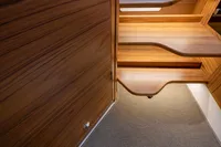 Luxurious wooden interior of 2022 Nimbus T11 boat, featuring elegant stairs and carpeted flooring.