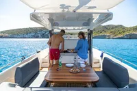Couple enjoying a meal on a 2022 Nimbus T11 yacht in scenic waters.