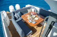 Luxurious 2022 Nimbus T11 yacht deck with dining setup and ocean view.